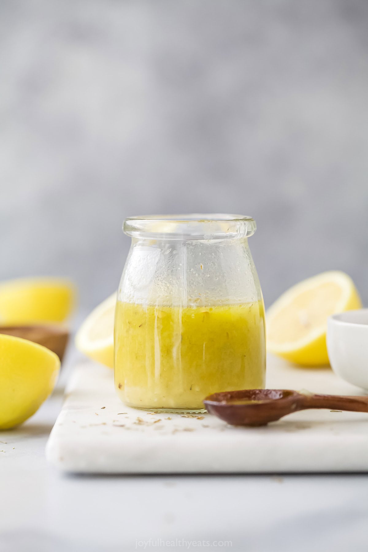 This 5-minute lemon vinaigrette with garlic, spicy mustard, and honey is an easy whisked dressing for your favorite salads. Homemade lemon vinaigrette in a glass jar.