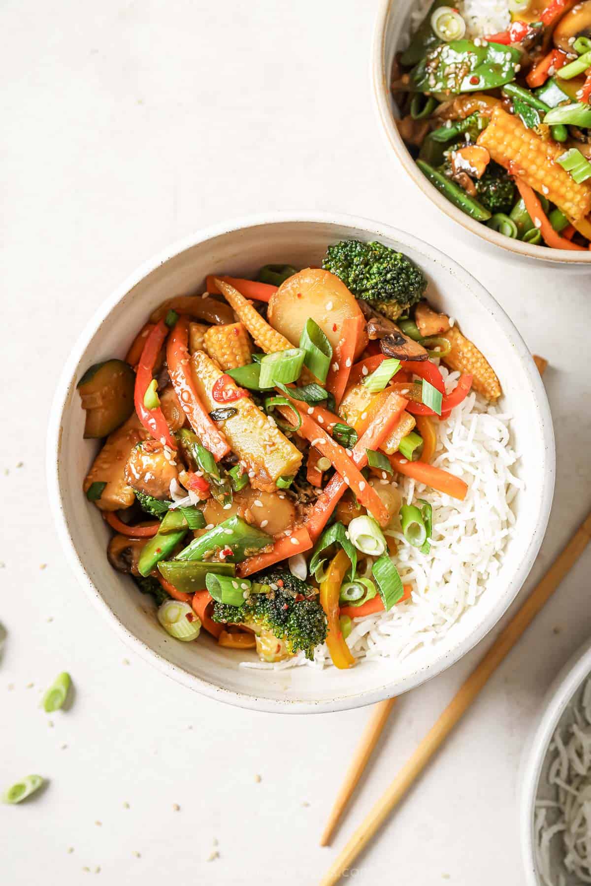 This vegetable stir fry is feel good food! It’s tasty, easy and packed with ALL the veggies. You'll love the sweet, savory, garlicky sauce! Overhead view of vegetable stir fry in bowl with rice