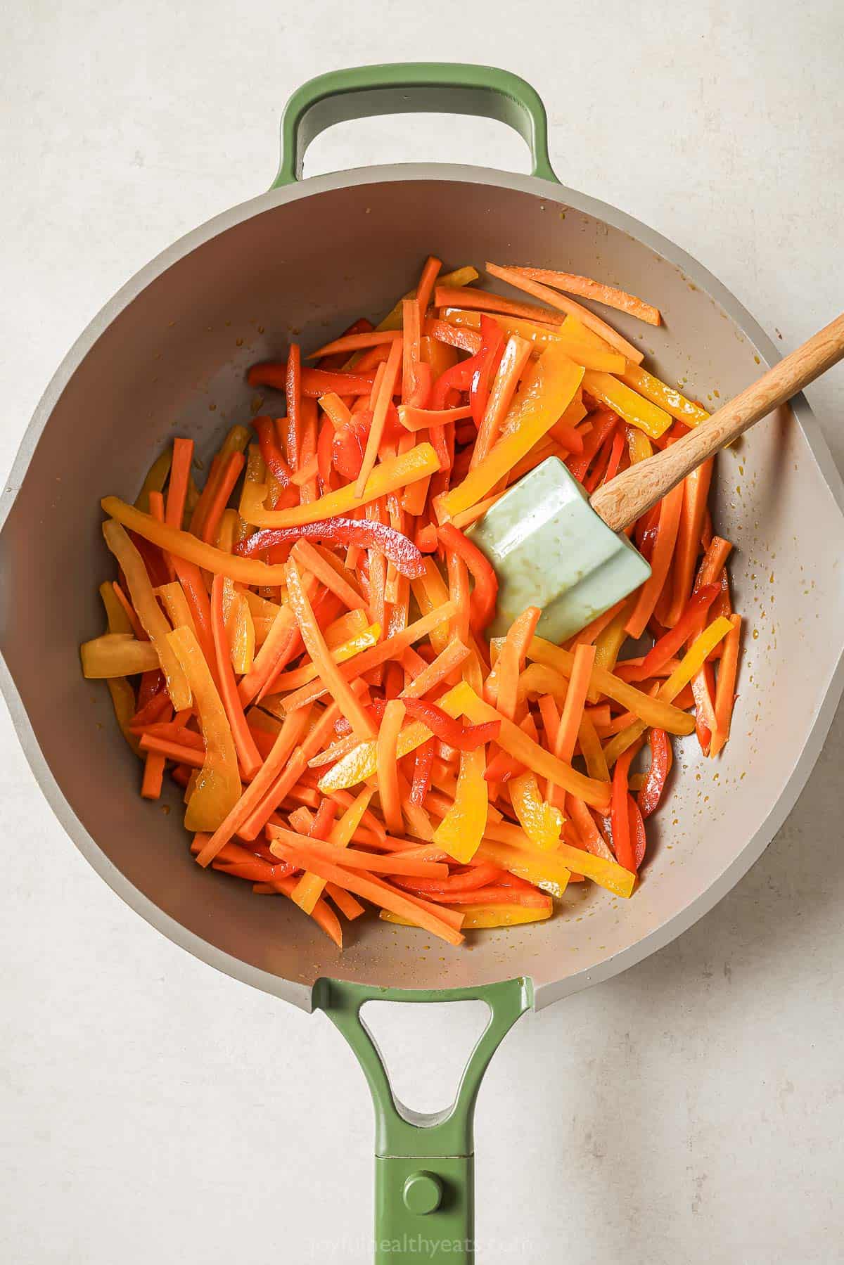 Overhead view of carrots and bell peppers in skillet