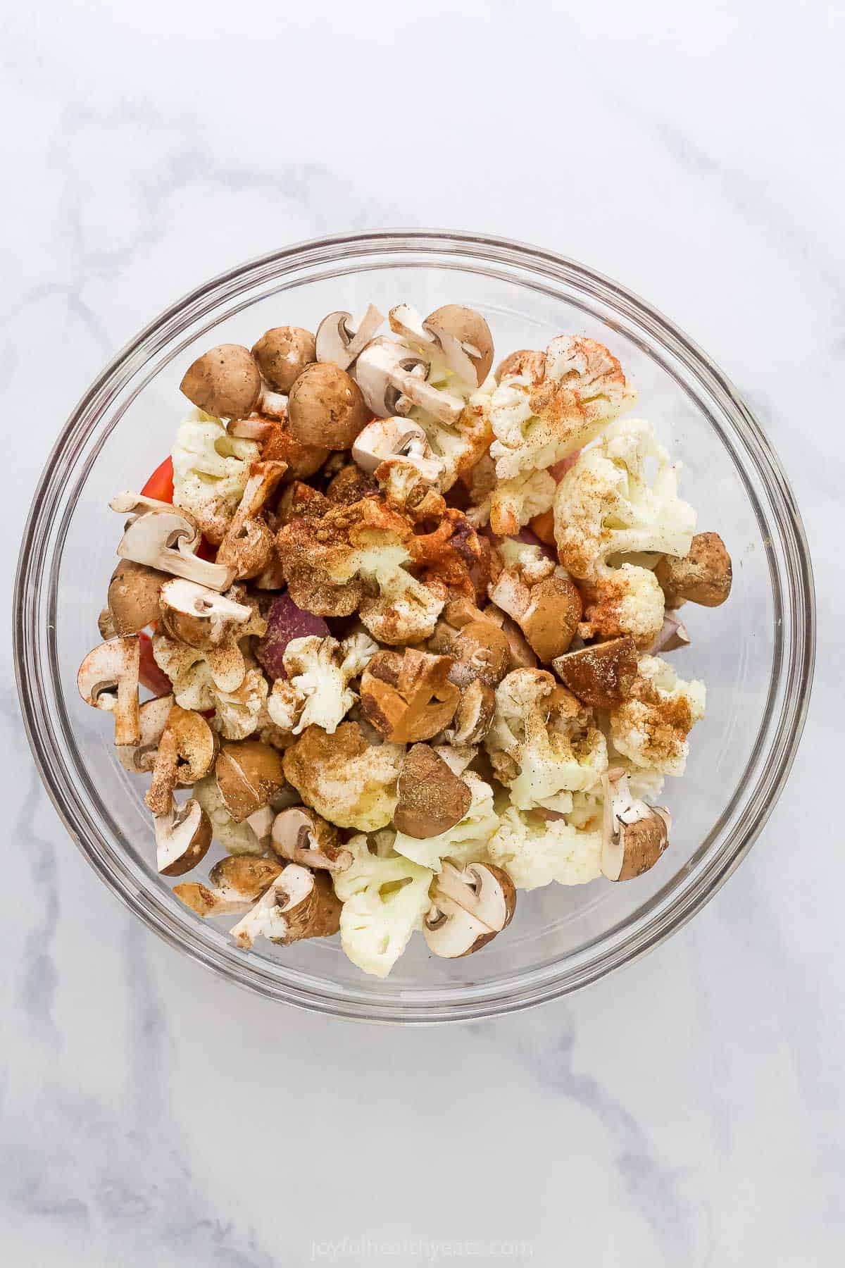 Adding the veggies and seasonings to a large bowl. 