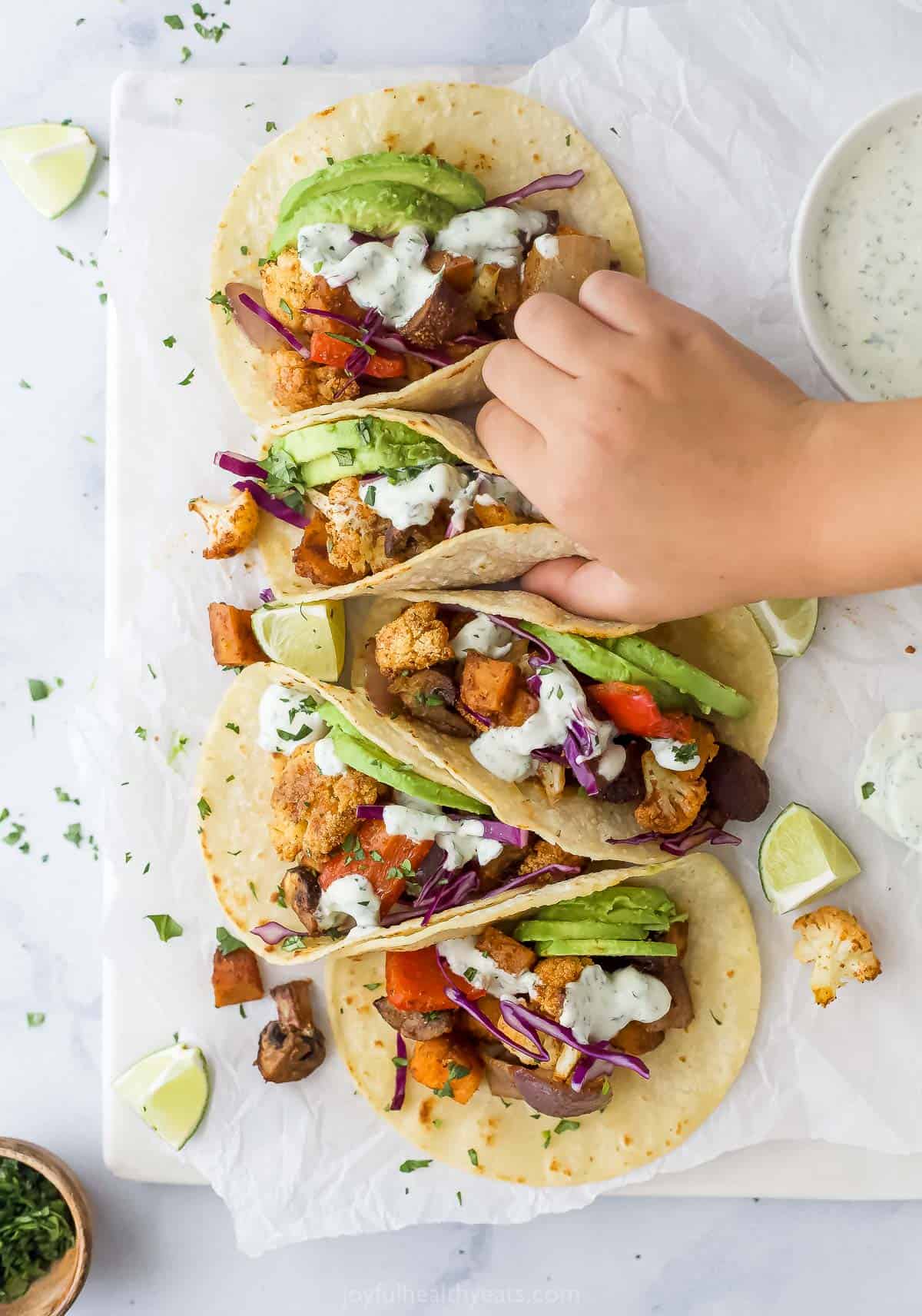Grabbing a freshly-made taco with avocado and red cabbage. 