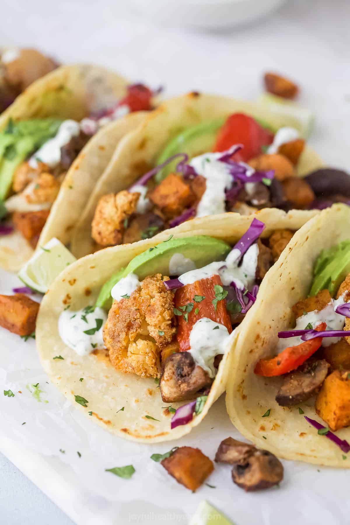 Close-up of the tacos with avocado, red cabbage, and homemade crema on top. 