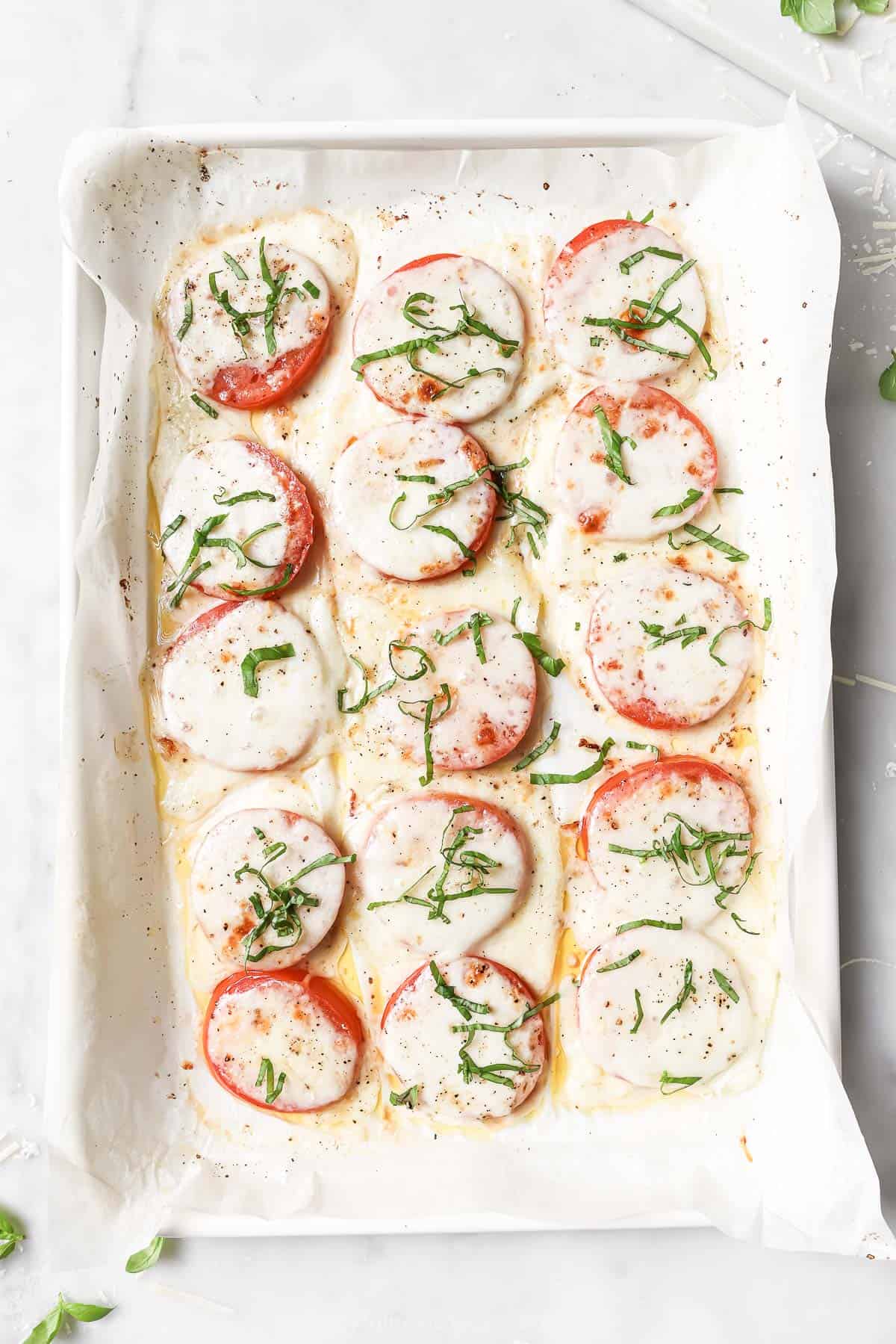 Baked tomatoes on the lined baking sheet. 