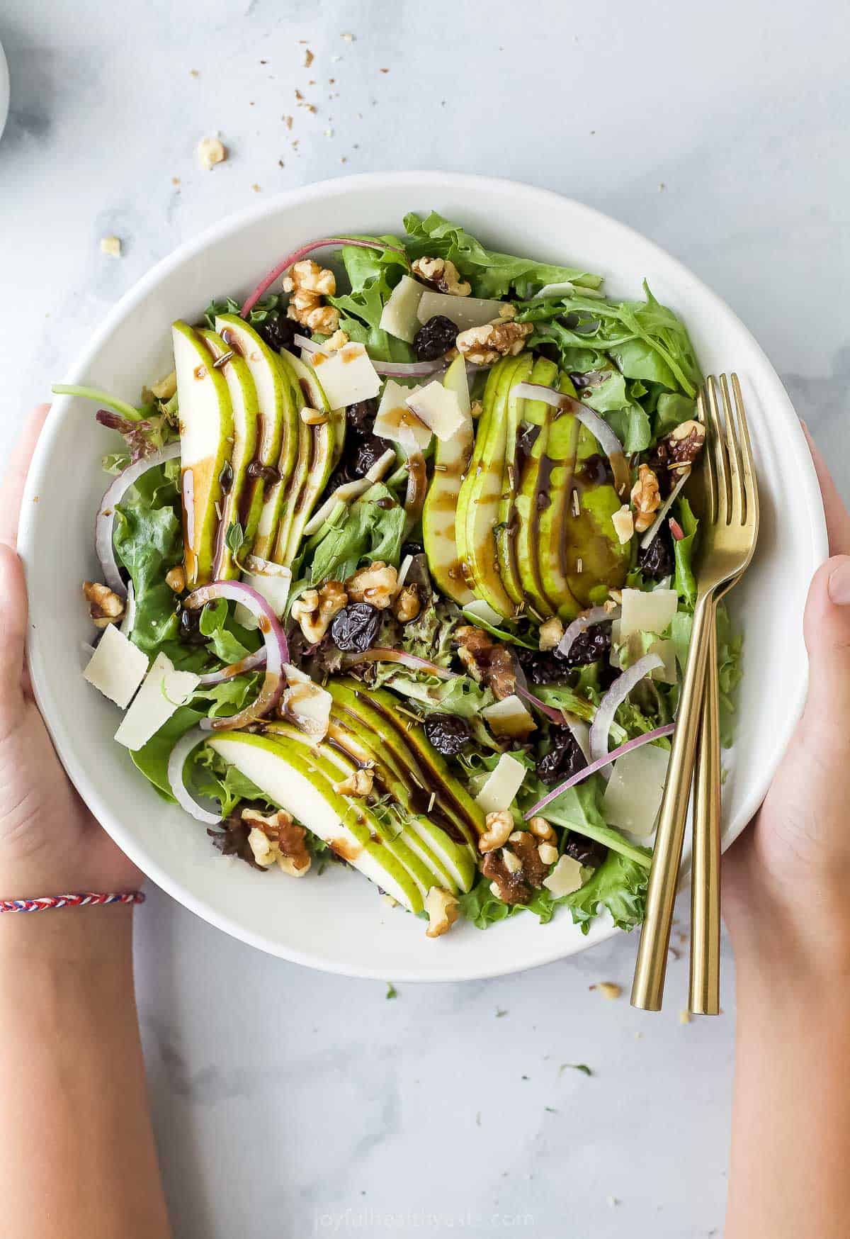 Bowl of my holiday pear salad with walnuts, cherries, parmesan, and balsamic vinaigrette.