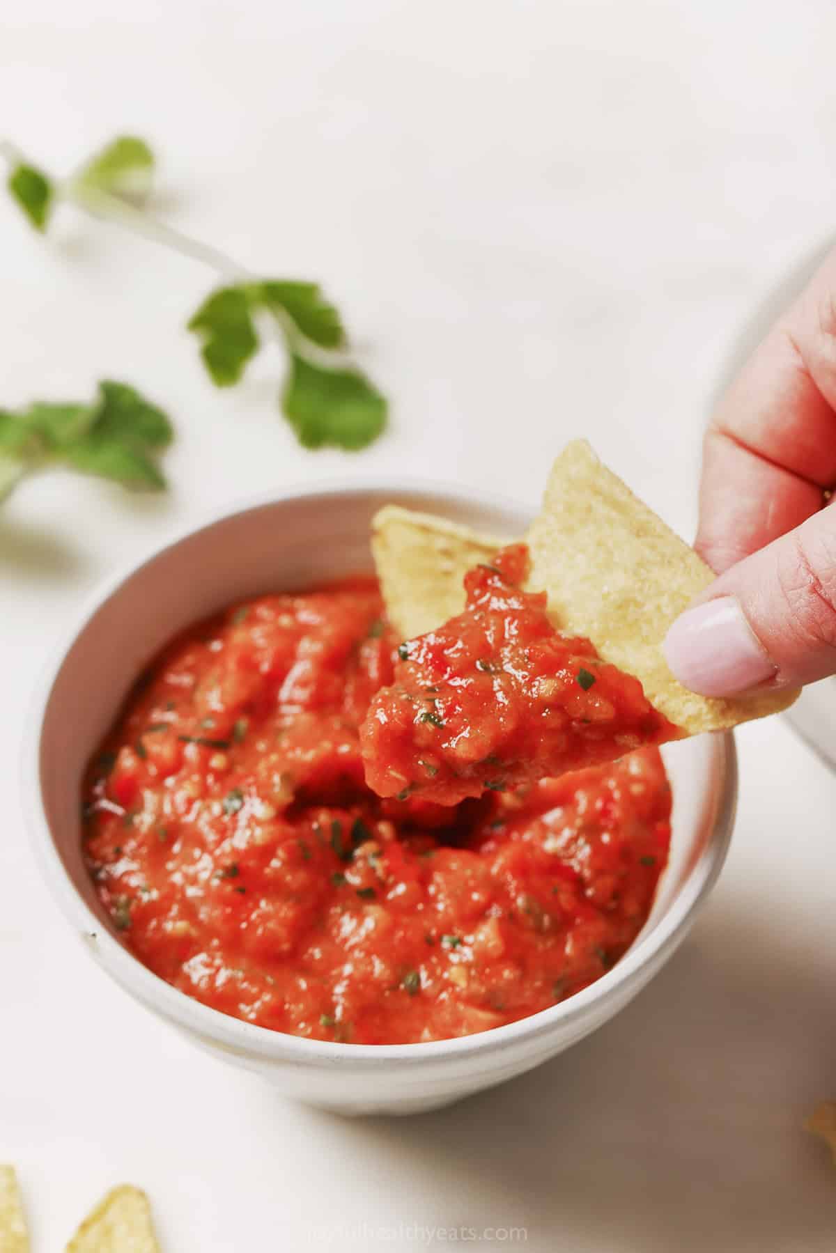 Dipping a chip into the homemade salsa. 