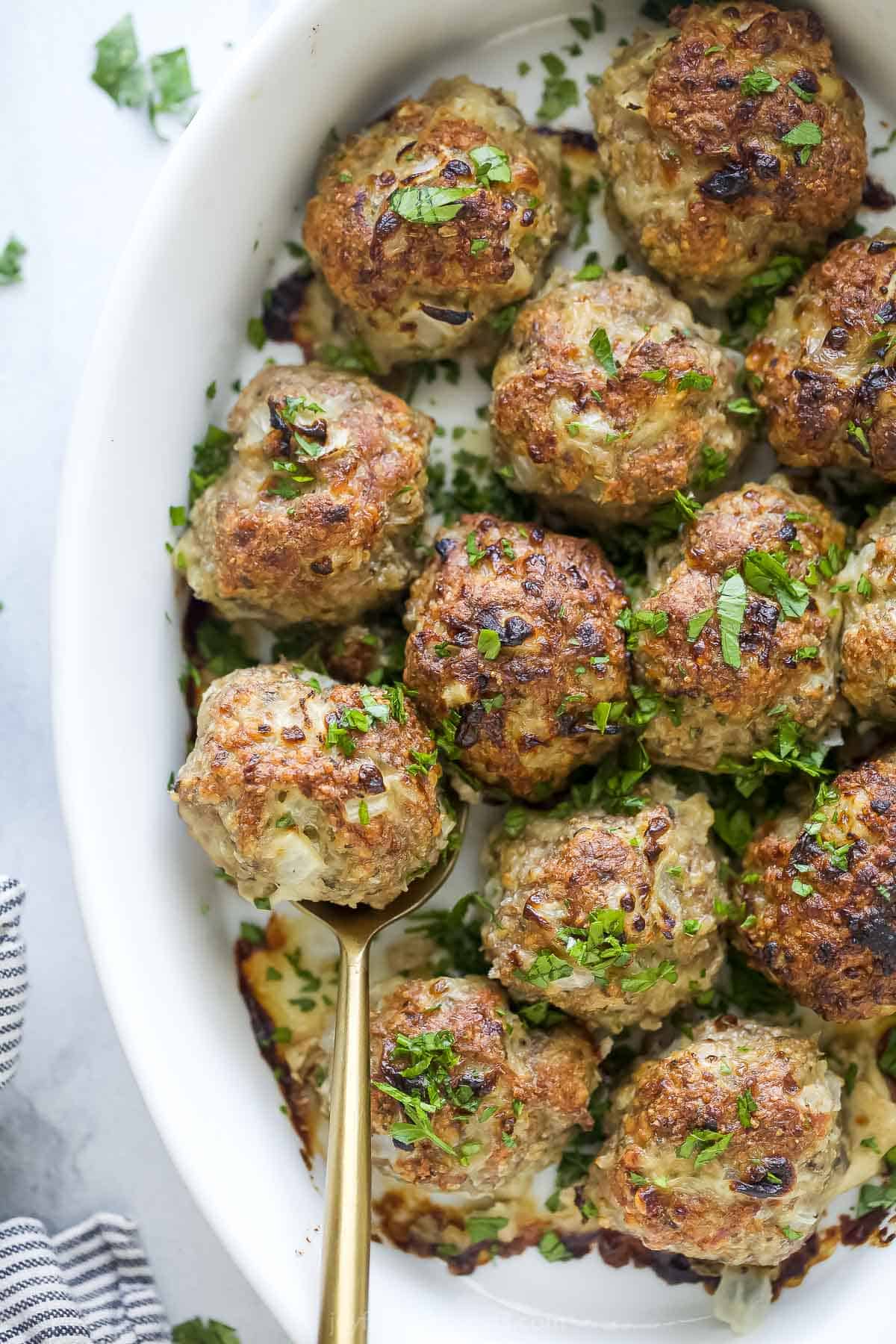 This juicy turkey meatballs recipe with fragrant garlic, herby oregano, and savory parmesan is an easy Italian dinner. Juicy turkey meatballs with fresh parsley on top.