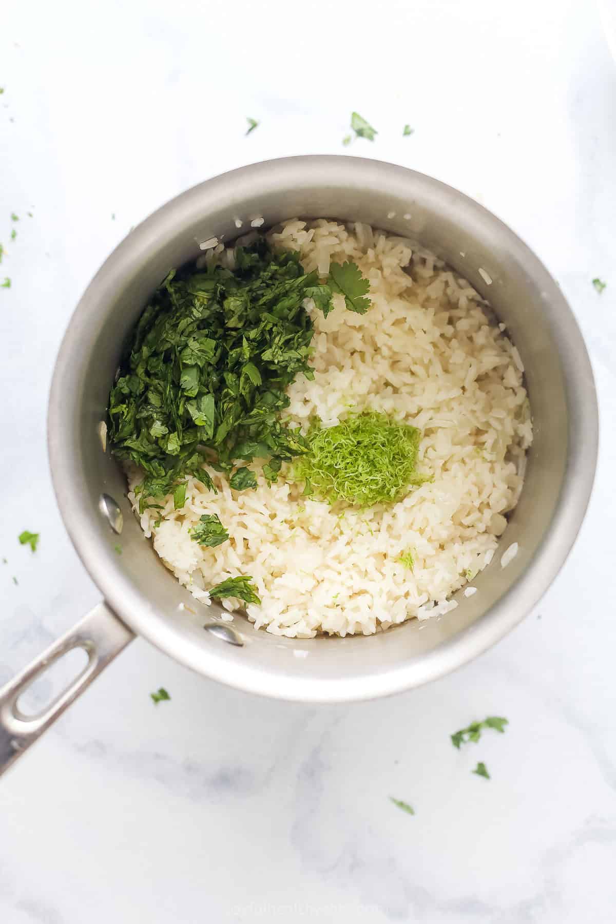 Adding the lime juice, zest, and cilantro to the cooked rice. 