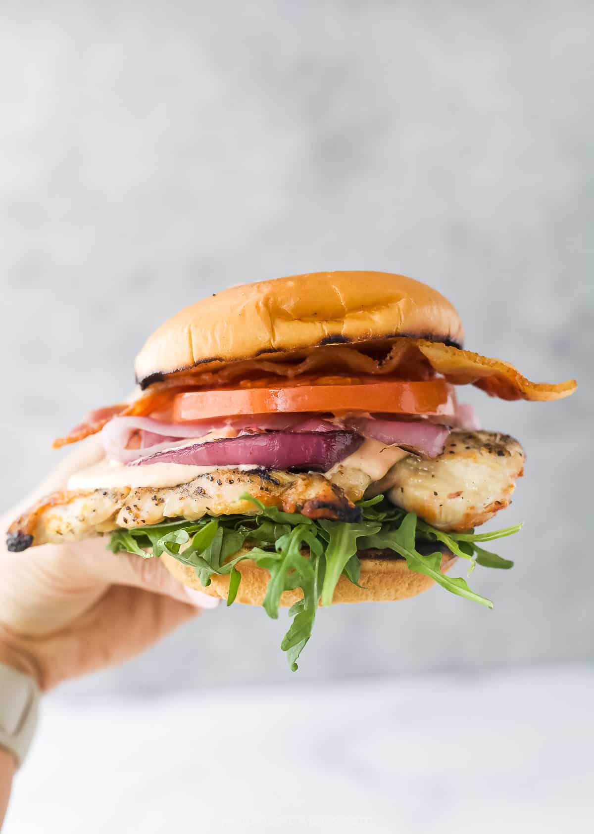 Close-up of all the layers in a grilled chicken sandwich.