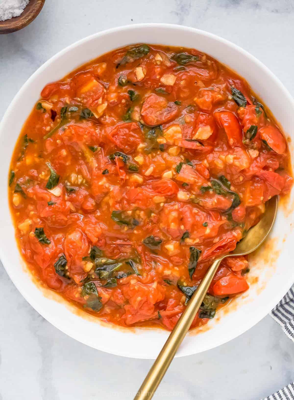 Overhead view of pasta sauce recipe in bowl with spoon