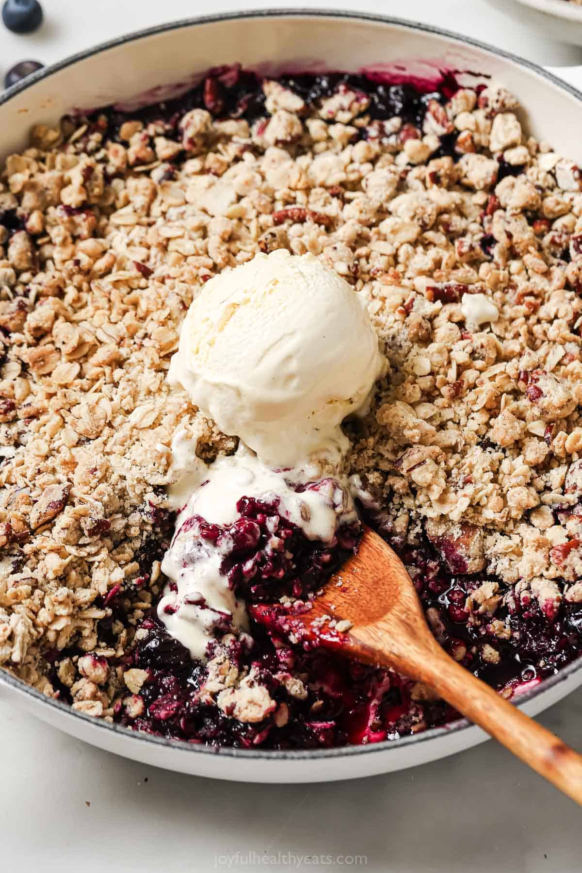 This baked blueberry cobbler recipe with buttery crumble is an easy summer dessert packed with crunchy pecans, oats, and fresh blueberries. Blueberry cobbler with a scoop of vanilla ice cream.