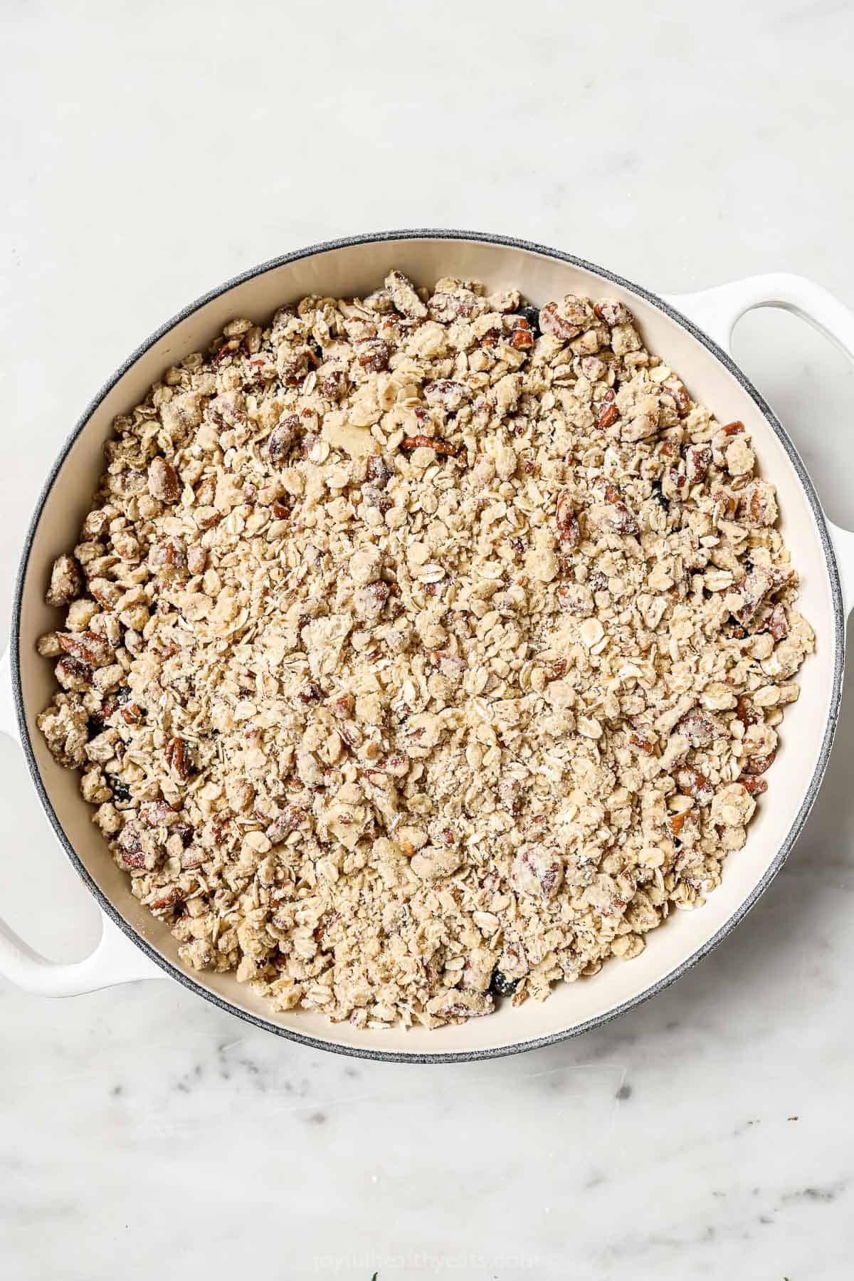 Sprinkling the crumble over the fruit filling. 