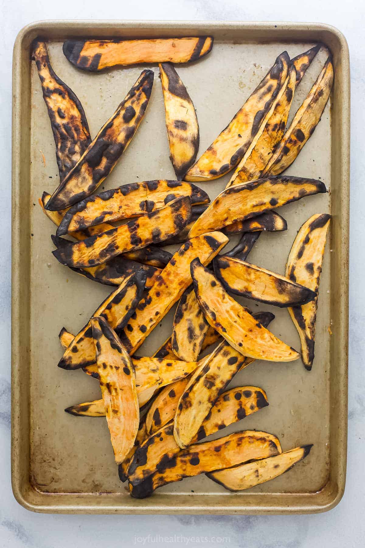 Grilled sweet potatoes on a baking sheet. 
