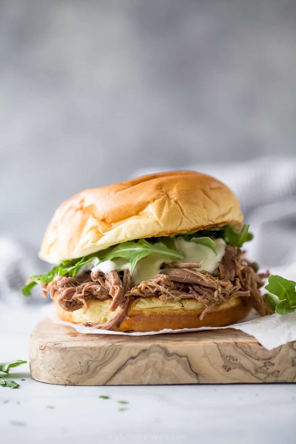This crockpot shredded beef sandwiches recipe with fresh arugula and homemade aioli is an effortless weekday lunch. Homemade shredded beef sandwich with arugula, horseradish aioli, and melty provolone cheese.