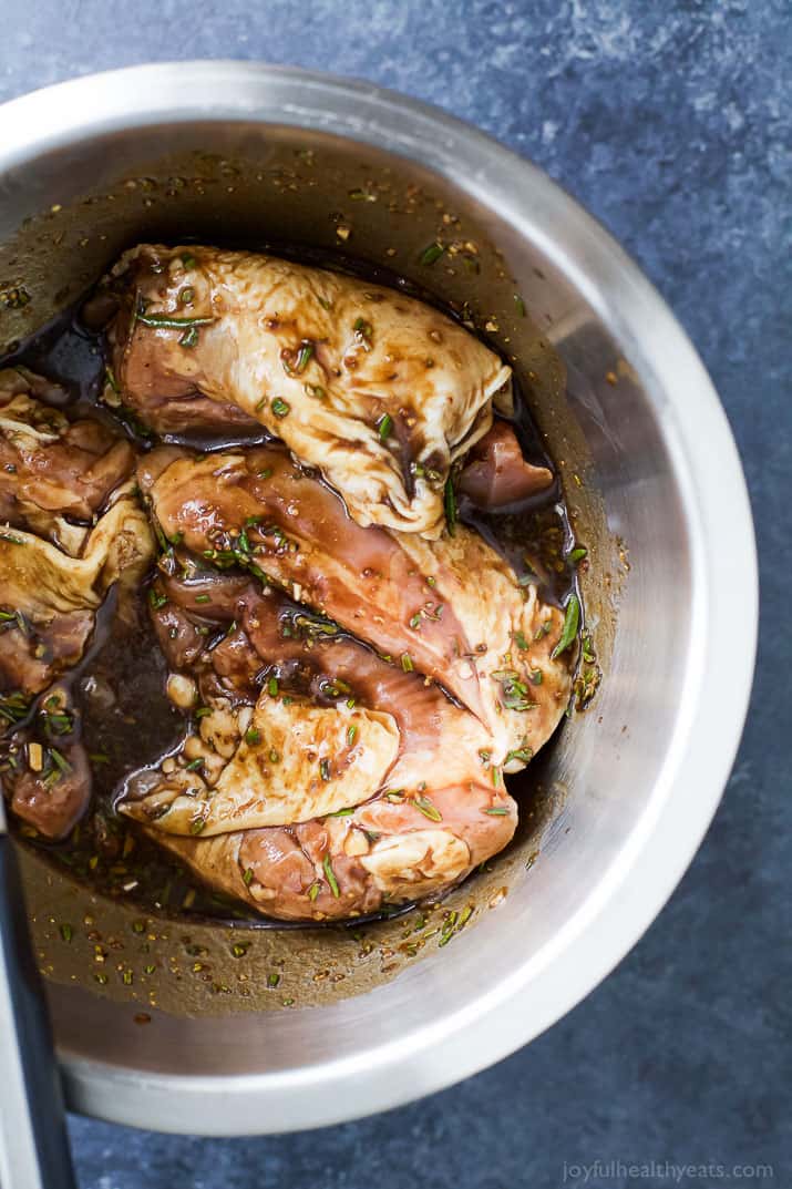Marinating the chicken thighs in balsamic glaze in a bowl. 