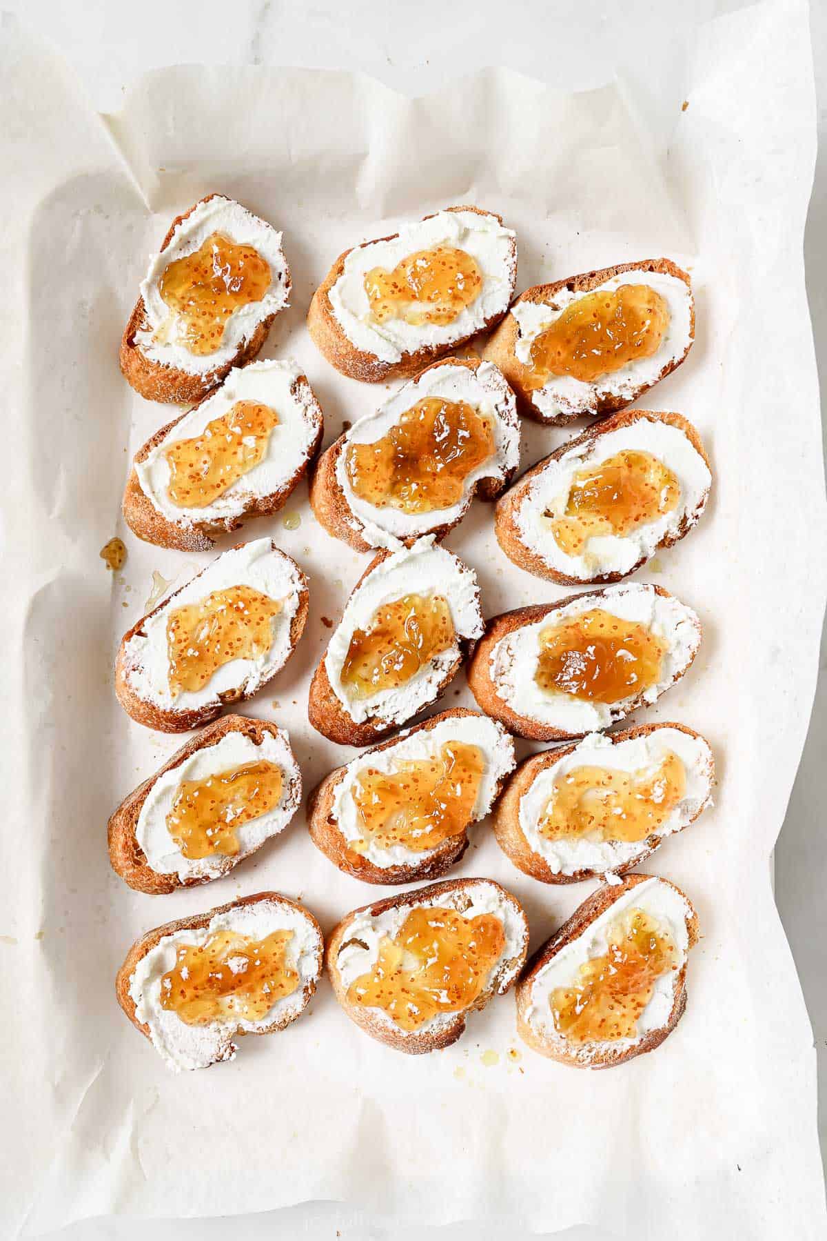 Sliced bread spread with goat cheese and fig jam. 