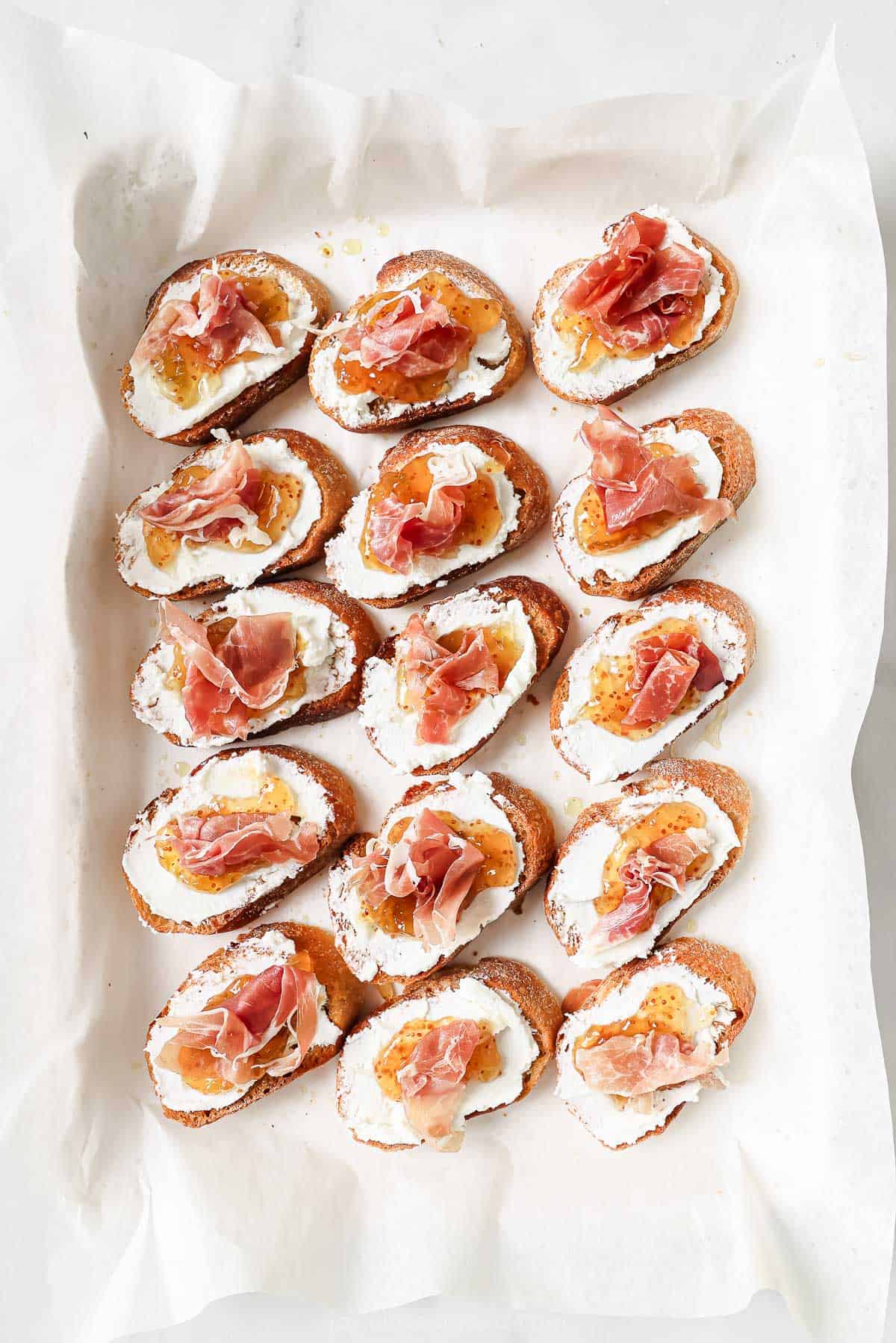Toasty crostinis with goat cheese, fig jam, and prosciutto.