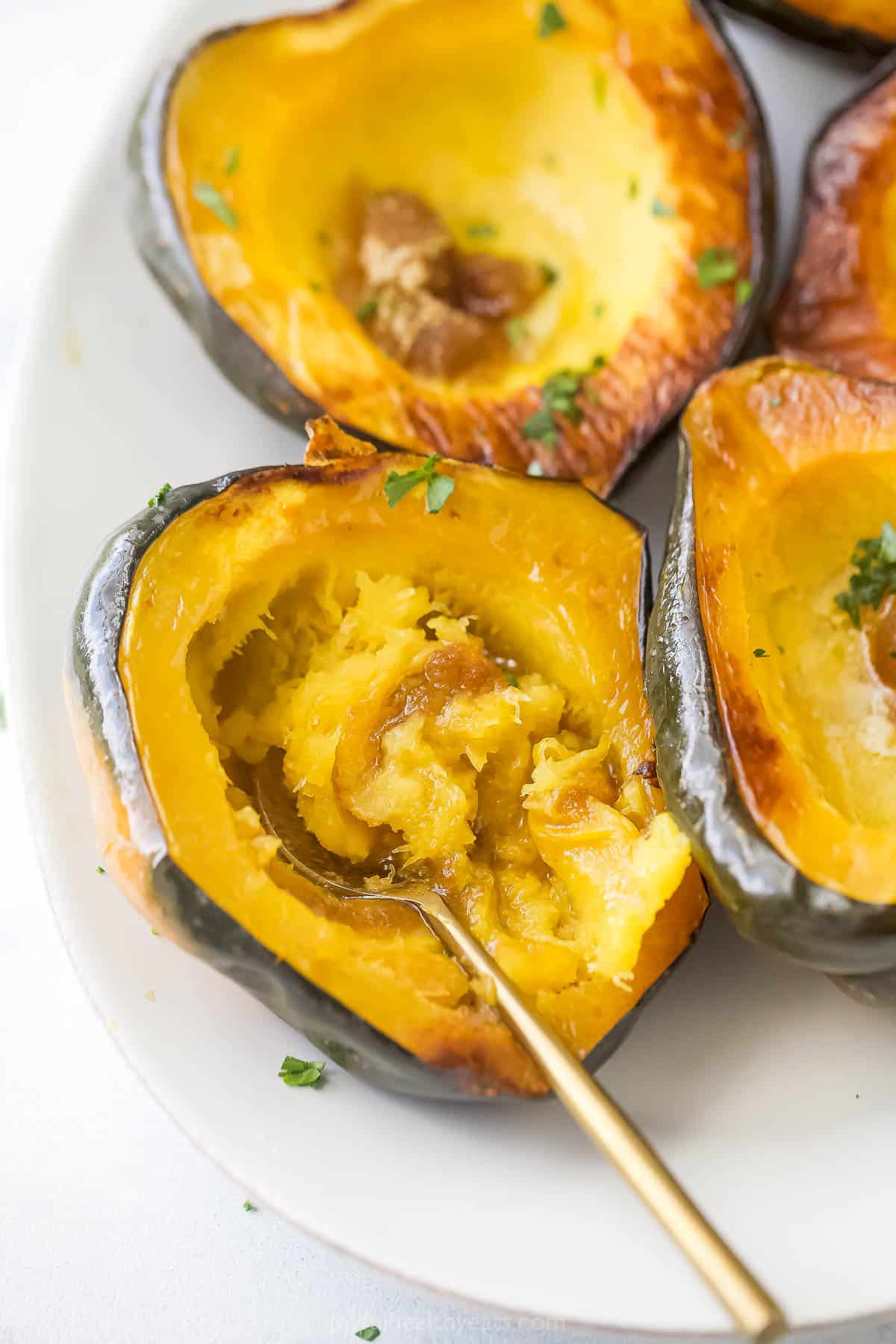 This buttery roasted acorn squash recipe with dark brown sugar is an effortless holiday side packed with fall flavors. Digging into a roasted acorn squash with butter and brown sugar.