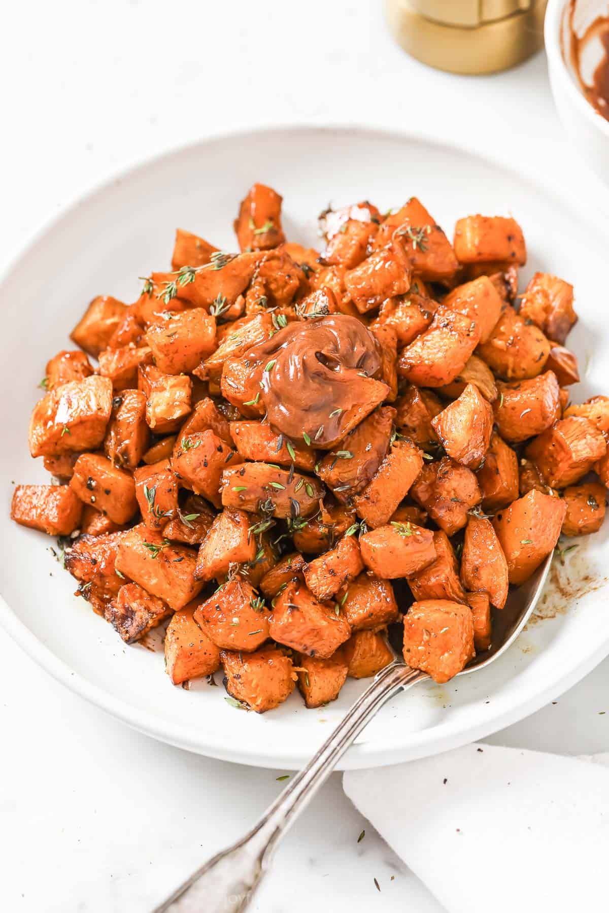 This sweet potato hash recipe with tender butternut squash and cinnamon-spiced butter is the perfect sweet holiday side for dinner. Sweet potato hash with butternut squash and cinnamon butter in a serving bowl.