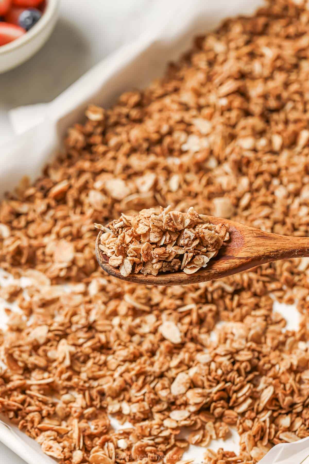 Spoonful of granola held over pan