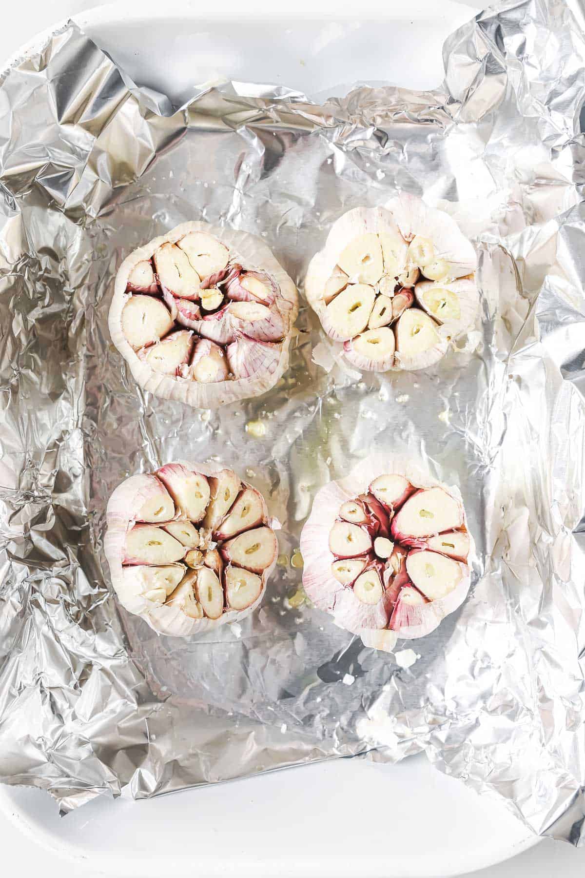 Garlic bulbs in pan with oil