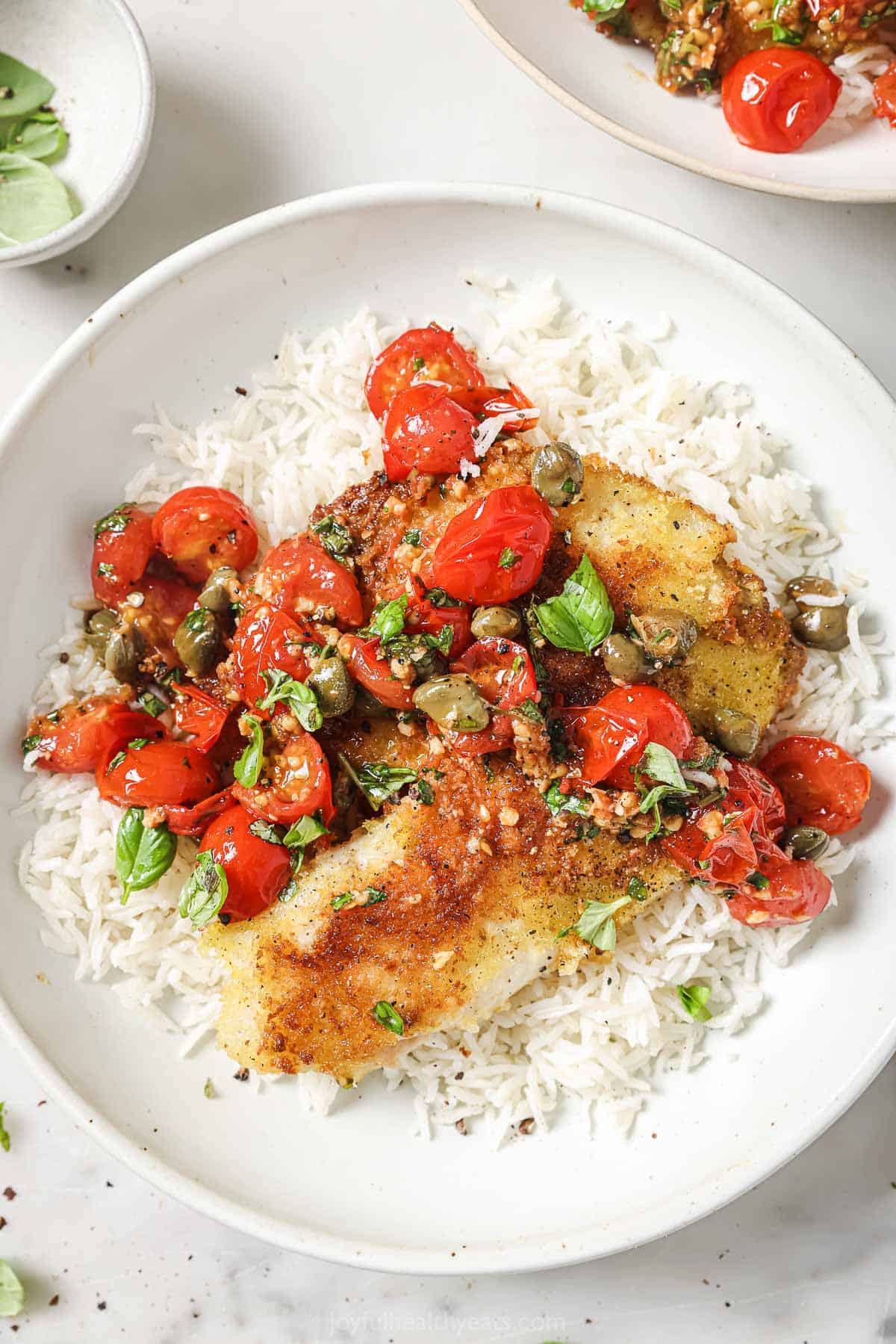 This 30-minute panko crusted tilapia recipe topped with homemade tomato-caper sauce is an easy weeknight dinner. Panko crusted tilapia with homemade tomato-basil sauce over fluffy rice.