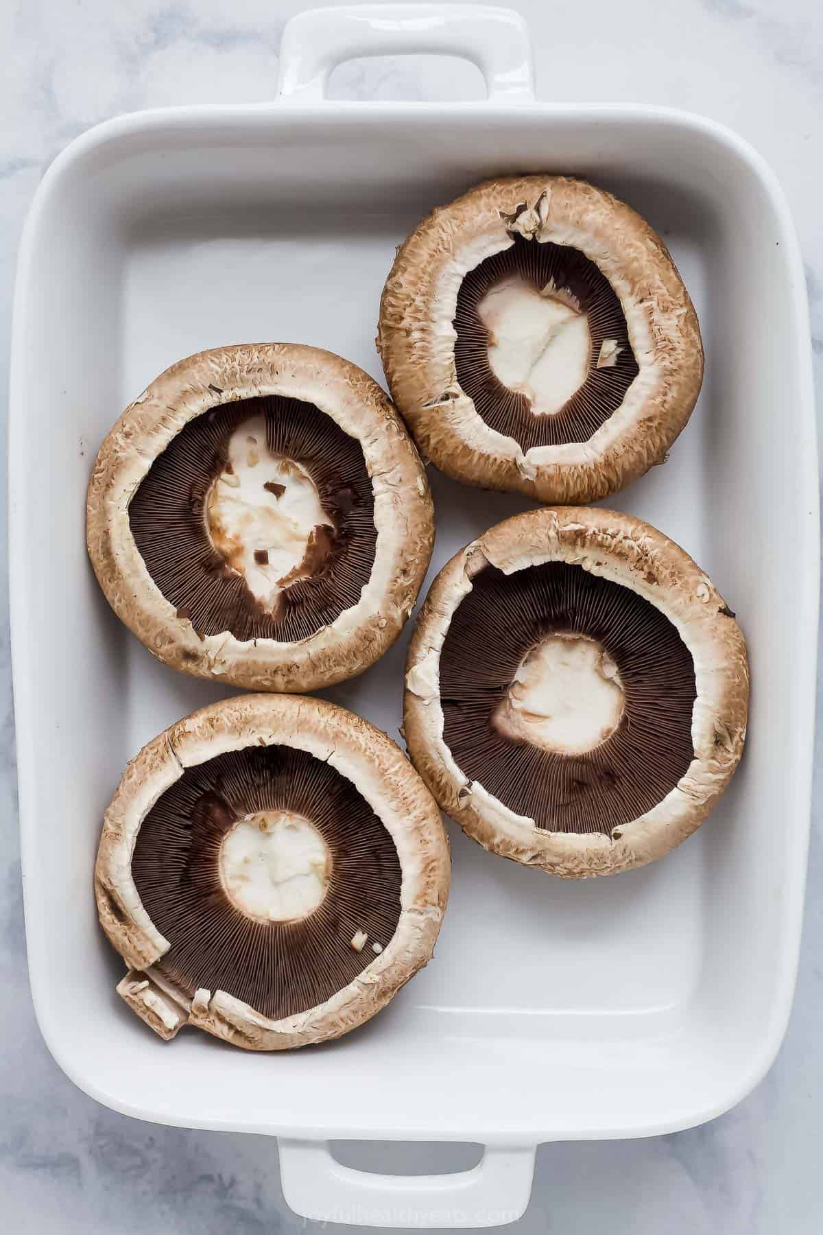 Overhead view of portobello mushrooms in baking dish