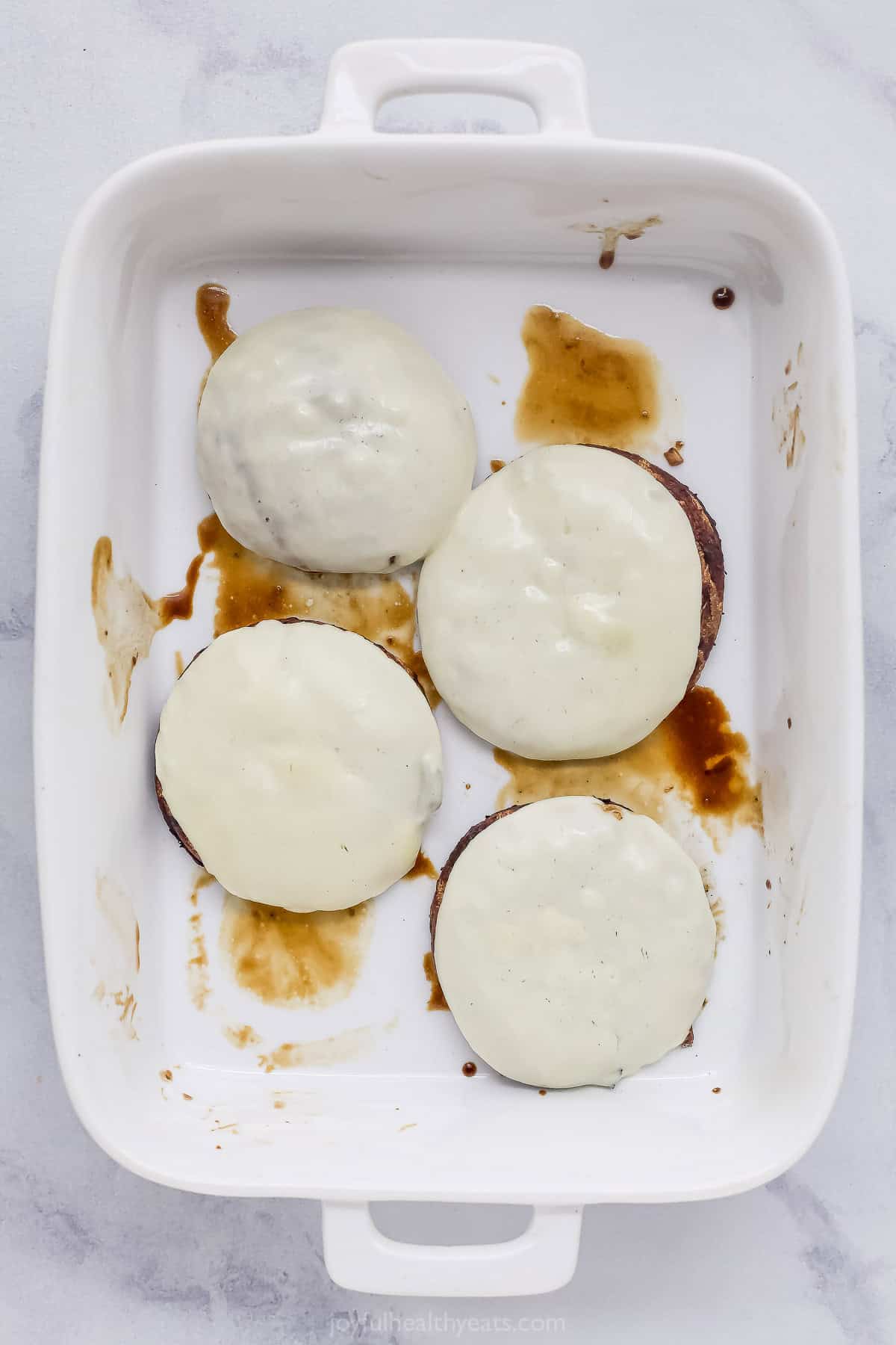 Overhead view of grilled portobello mushrooms topped with provolone