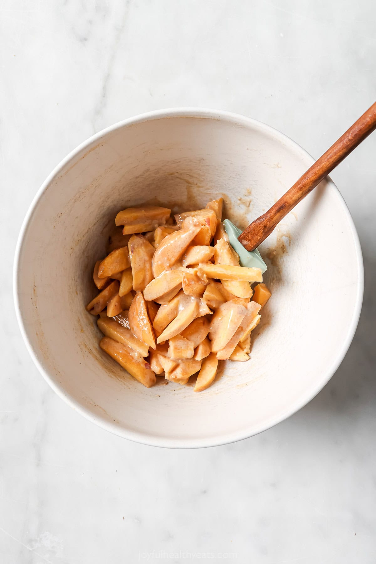 Stirring peaches with other filling ingredients in bowl