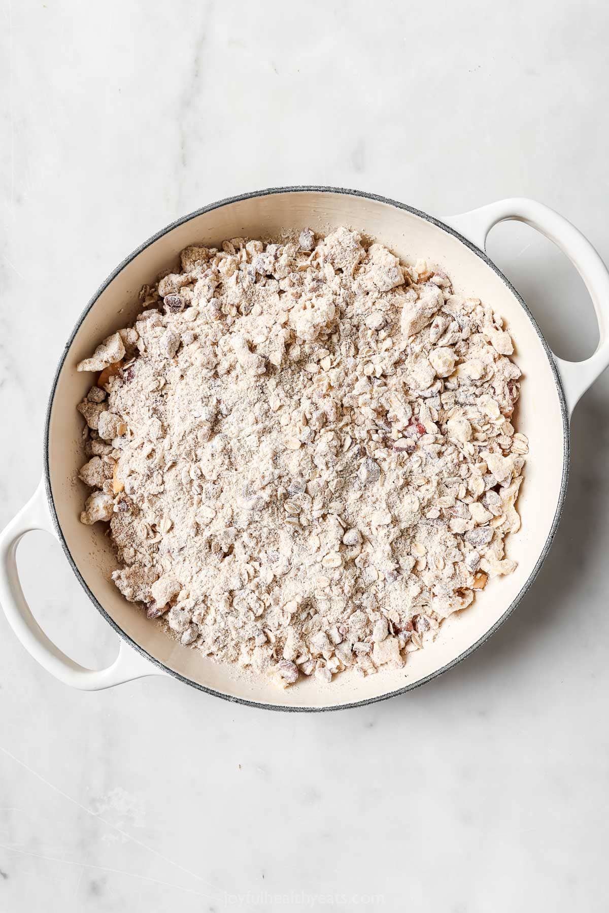 Skillet of raspberry peach crisp before baking