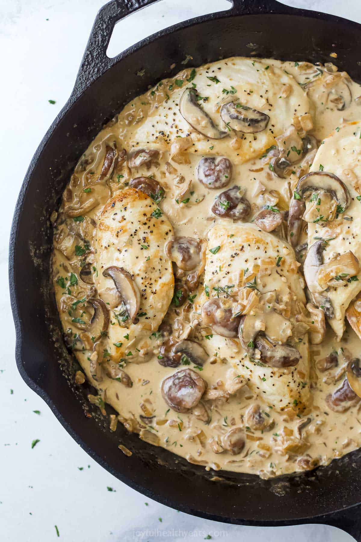 This pan-seared chicken with mushroom sauce recipe with tender onions and creamy coconut sauce always hits the spot on weeknights. Creamy chicken with mushroom sauce and thyme in the skillet.