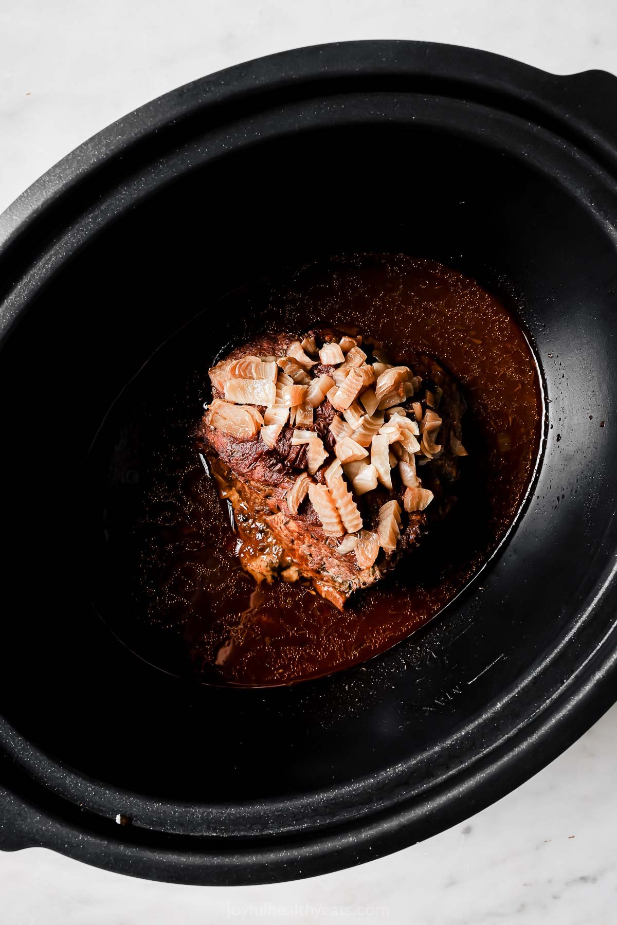 Cooked whole pork shoulder in the crockpot. 