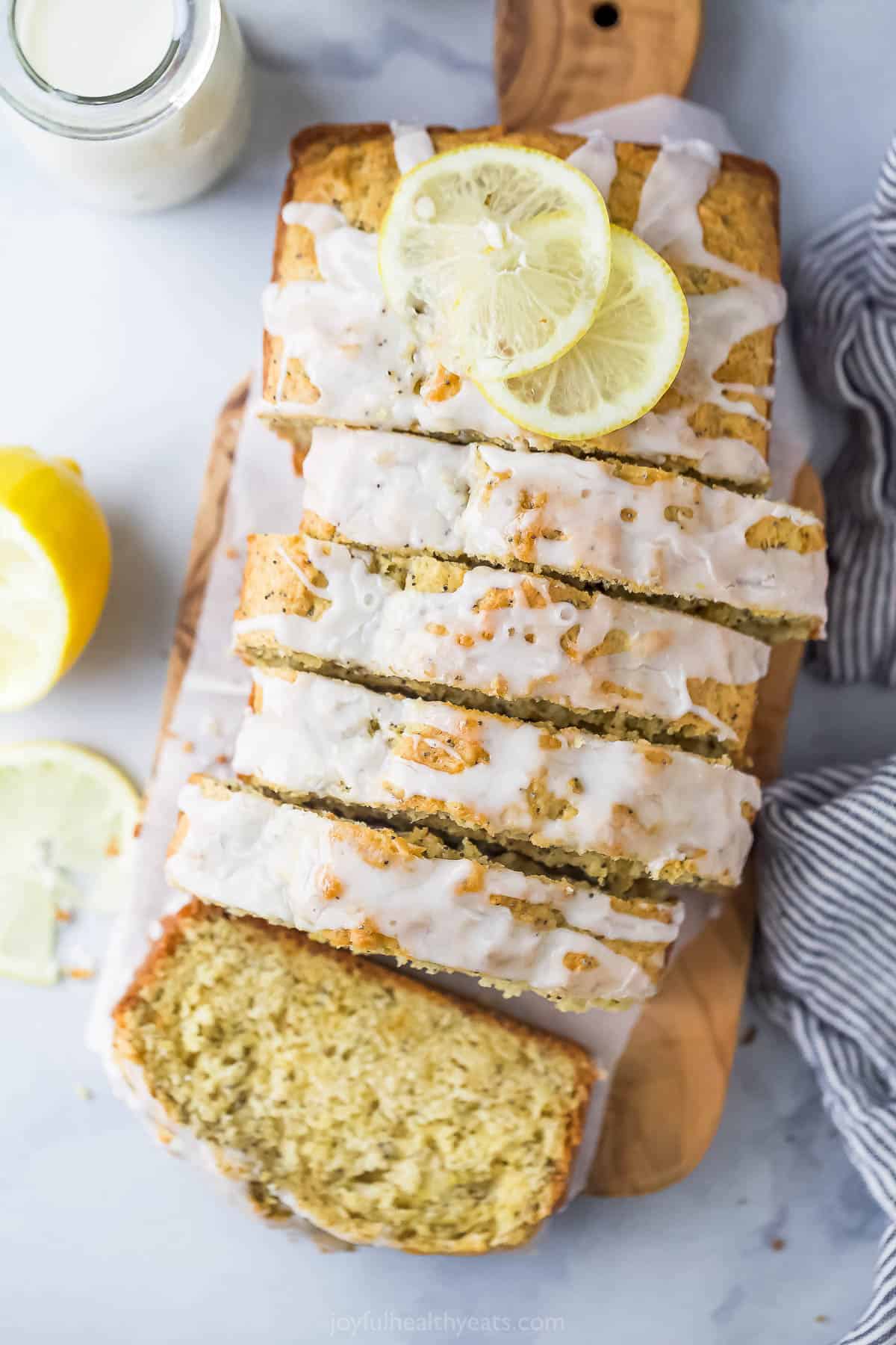 This lemon poppy seed bread is a zesty dessert-turned-breakfast packed with healthy ingredients like Greek yogurt for a guilt-free treat. Sliced lemon poppy seed bread with glaze on top.