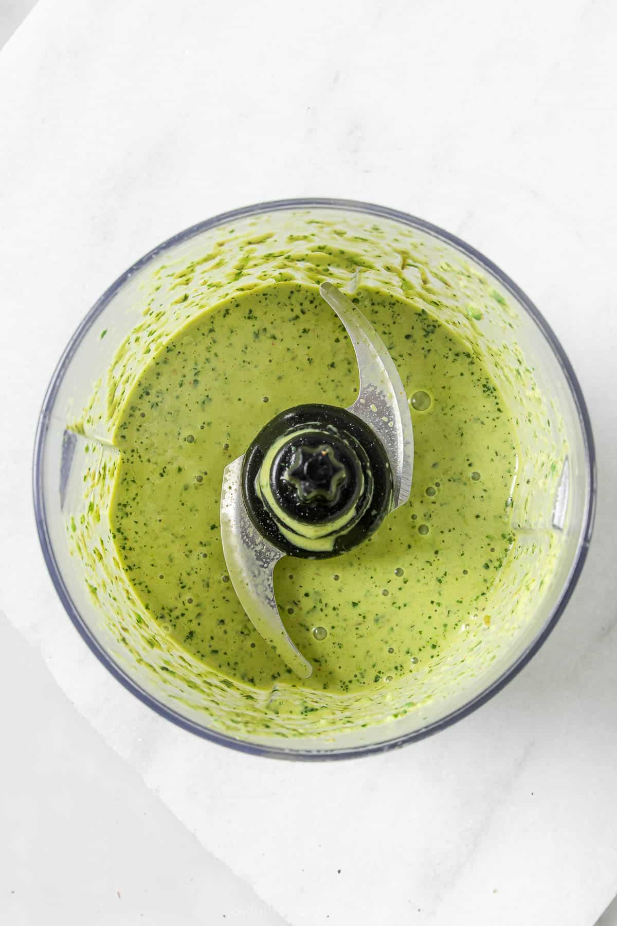 Overhead view of creamy poblano dressing in food processor bowl