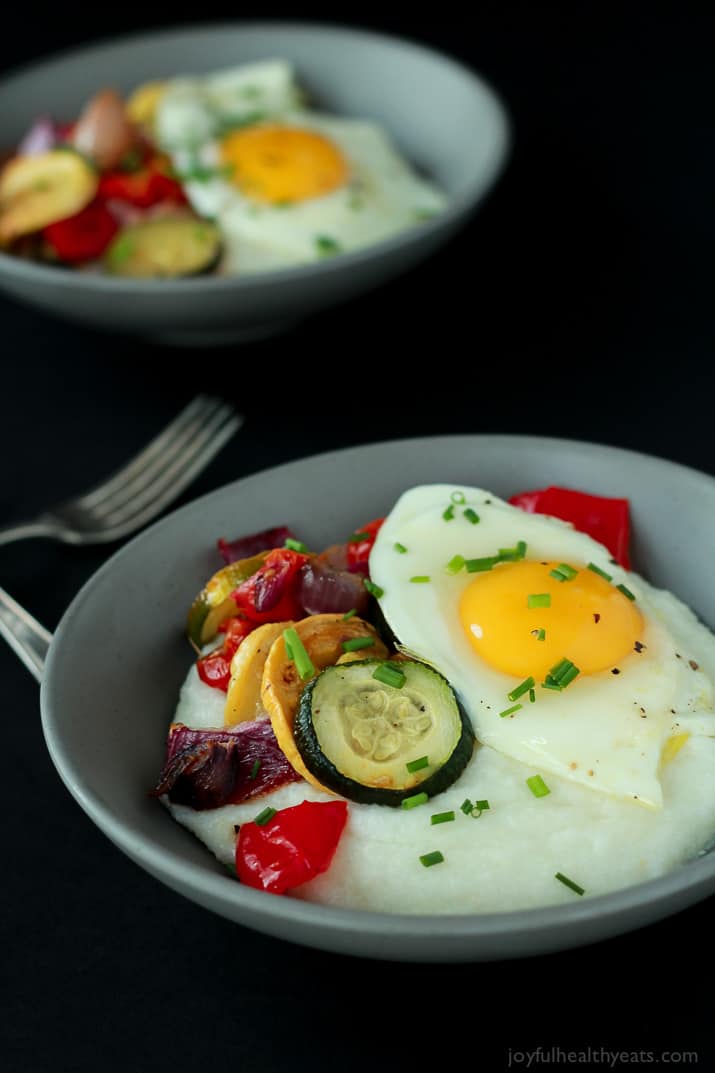 Creamy Goat Cheese Grits and Eggs with Roasted Vegetables Two Bowls of Grits with Eggs & Veggies Beside Two Forks