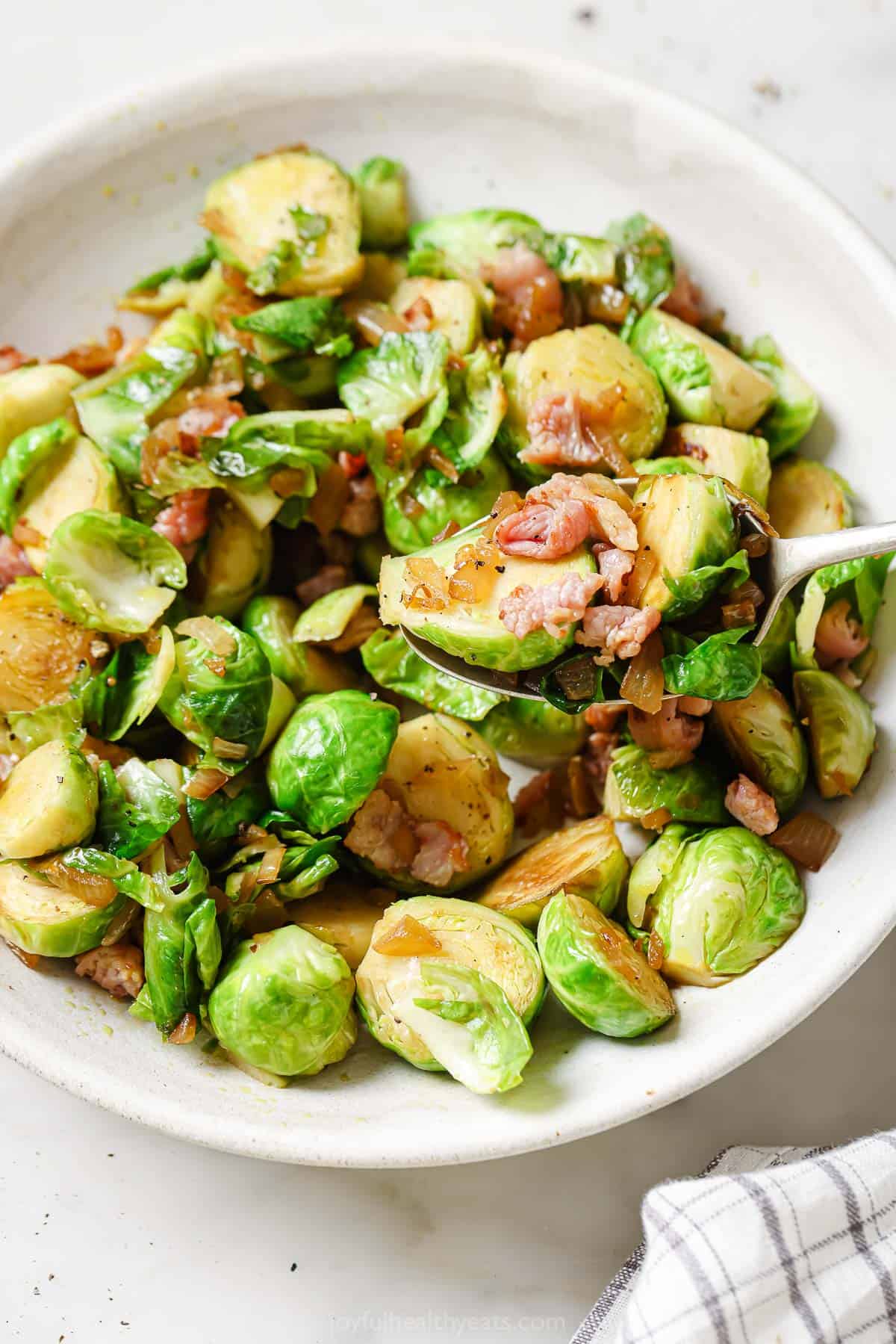 These tender sauteed brussels sprouts with caramelized onions and crispy bacon are the perfect 30-minute holiday side. Sauteed brussels sprouts with caramelized onions and bacon.