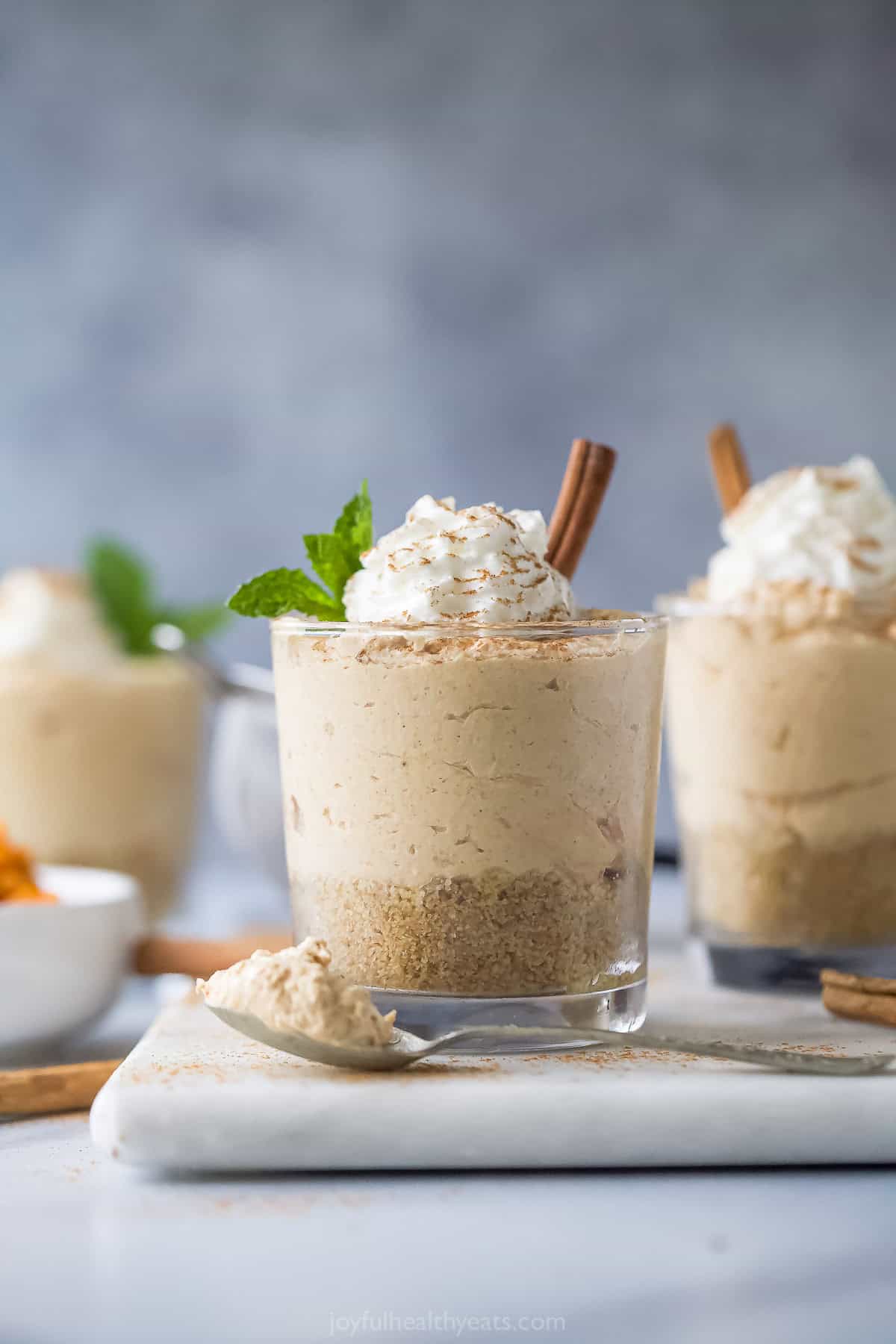 Serving glasses of no bake cheesecake with Cool Whip on top. 