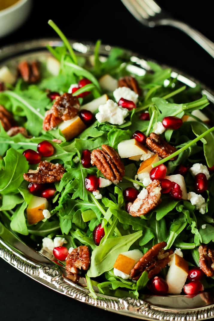 Pomegranate Goat Cheese Candied Pecan Arugula Salad. The perfect salad to change up your holiday menu, easy to make and absolutely delicious! | purewellnessjourneyclub.com