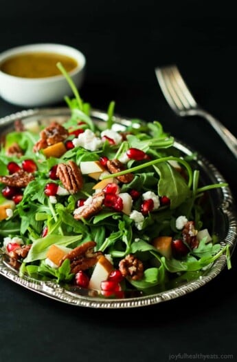 Pomegranate Goat Cheese Candied Pecan Arugula Salad. The perfect salad to change up your holiday menu, easy to make and absolutely delicious! | purewellnessjourneyclub.com