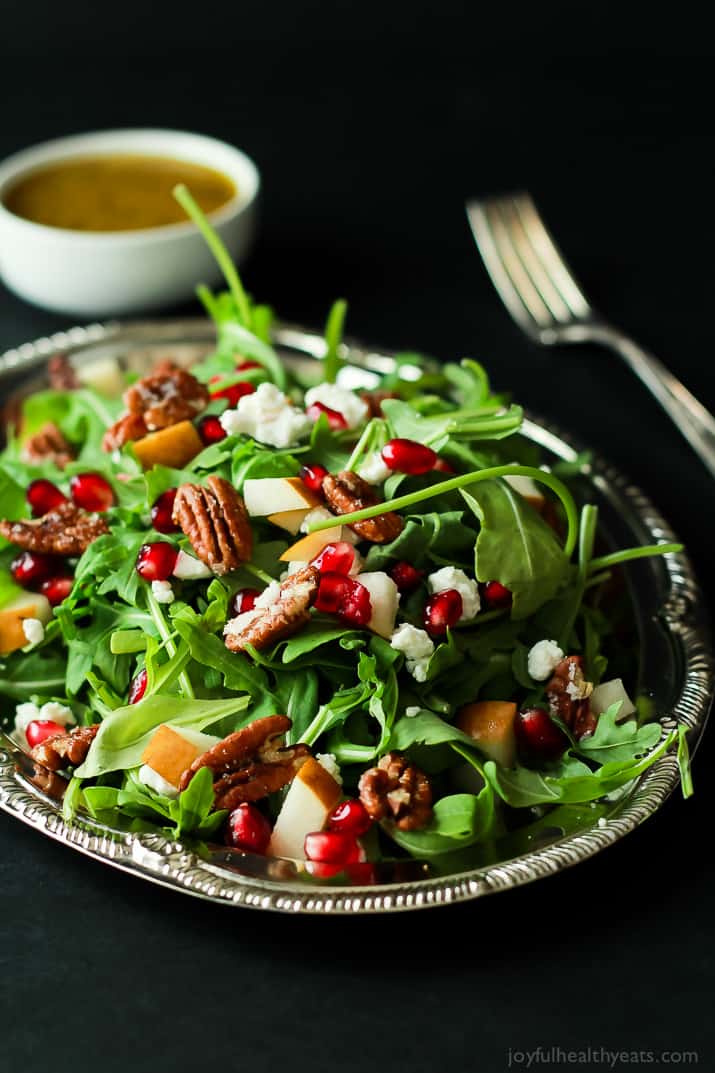 Pomegranate Goat Cheese Candied Pecan Arugula Salad. The perfect salad to change up your holiday menu, easy to make and absolutely delicious! | purewellnessjourneyclub.com