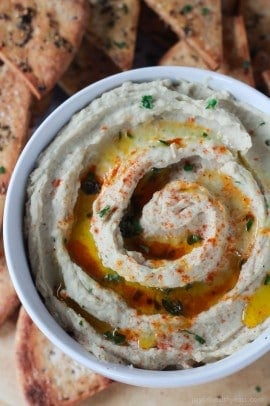 Roasted garlic and fresh basil make this White Bean Hummus to die for, great for a snack option or appetizer at the next party! | purewellnessjourneyclub.com #recipes #eathealthy15