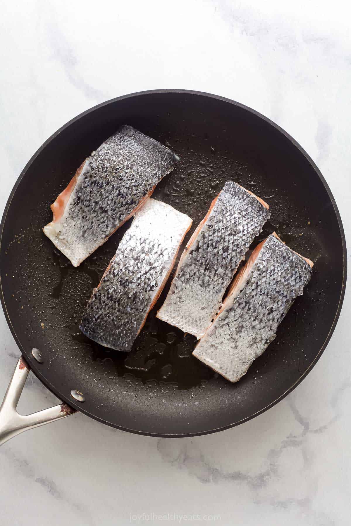 Searing the salmon with the skin facing upwards.
