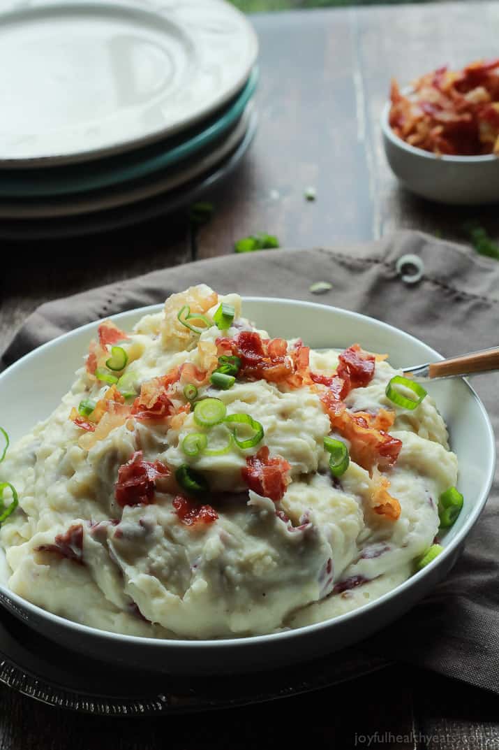 Creamy Goat Cheese Horseradish Mashed Potatoes A Bowl of Mashed Potatoes Next to a Stack of Plates and Additional Pancetta