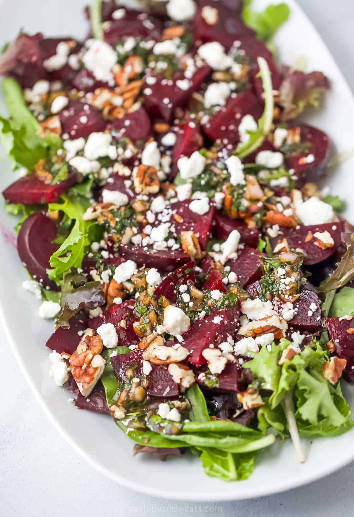 This roasted beet salad with goat cheese pairs sweet, earthy beets with crisp greens, creamy cheese and a lively honey Dijon vinaigrette. Yum! Roasted beet salad with goat cheese and pecans