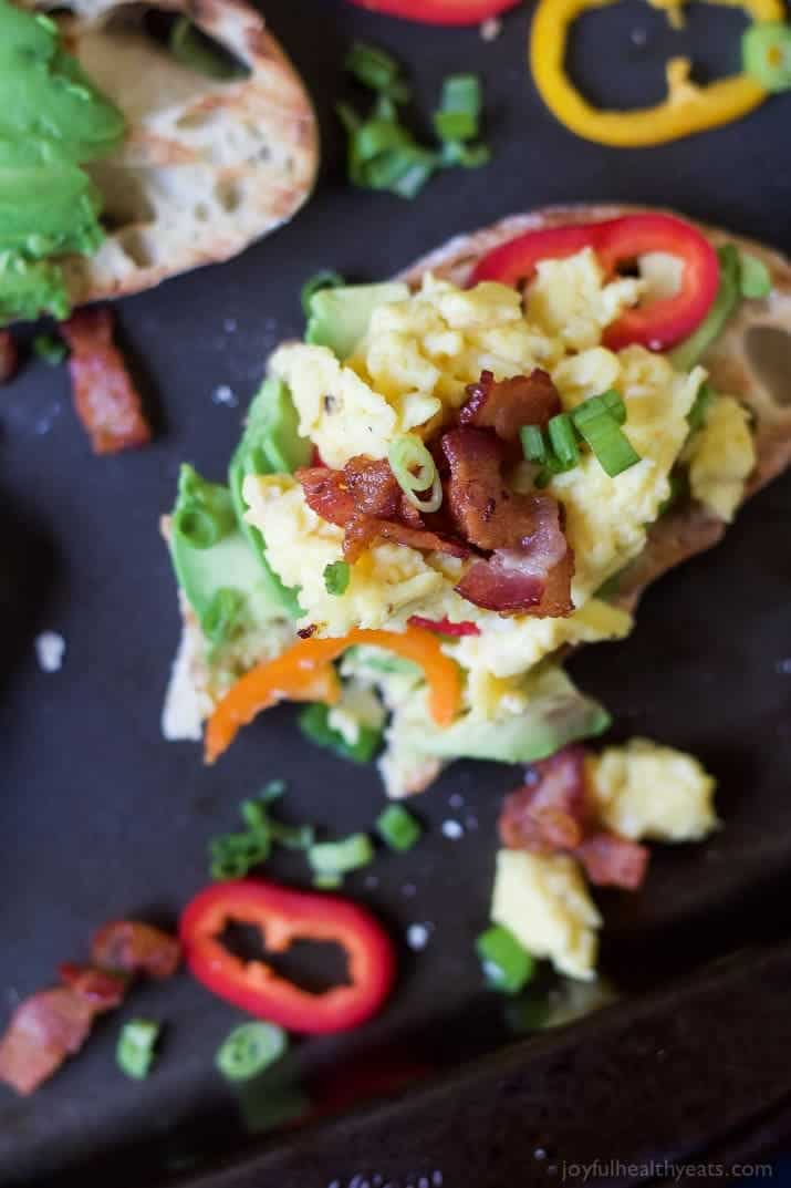 Breakfast Bruschetta on Avocado Toast A Serving of Breakfast Bruschetta Bread on a Black Surface