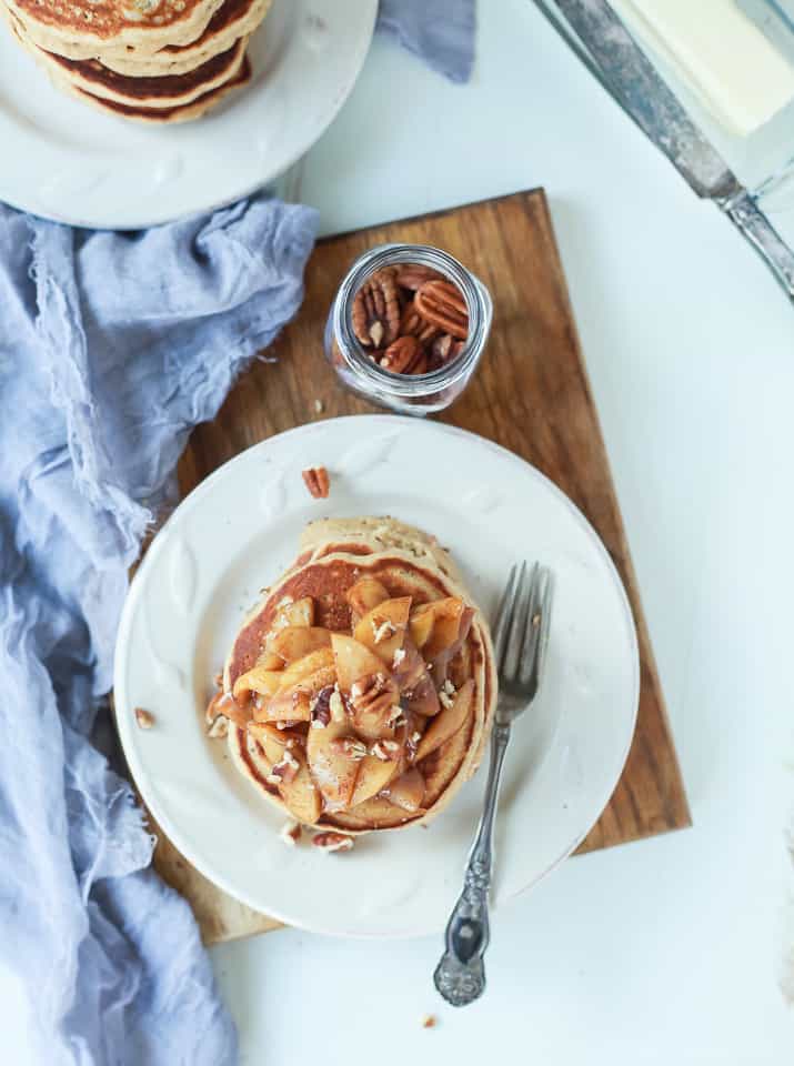 Top view of a stack of whole wheat pancakes topped with cinnamon apple compote.