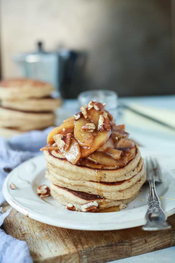 These fluffy whole wheat pancakes are topped with a cinnamon apple compote that's made with honey for a sweet, quick and easy breakfast. A stack of fluffy whole wheat pancakes topped with cinnamon apple compote.