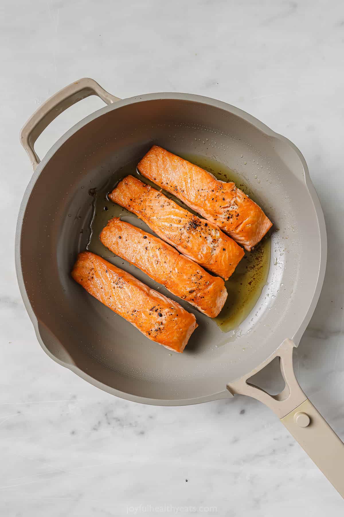 Searing the salmon in the pan.