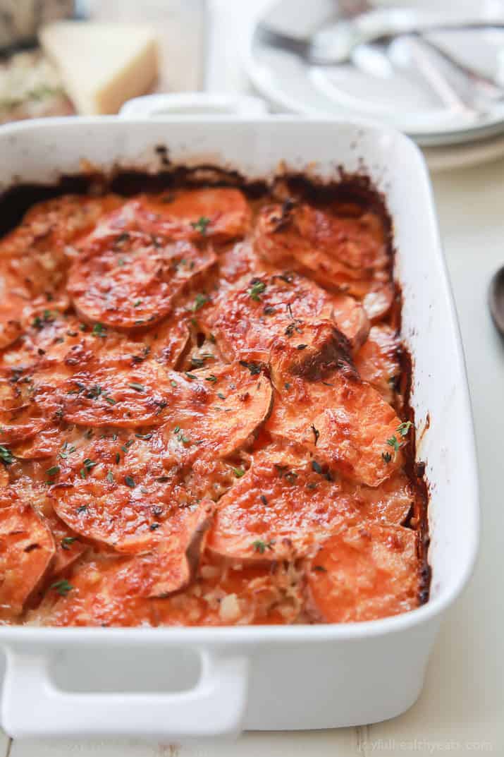 These scalloped sweet potatoes are made with rich cream, tender sweet potatoes, and fresh herbs! An easy casserole for the holidays and more. Cheesy scalloped sweet potatoes topped with fresh herbs.
