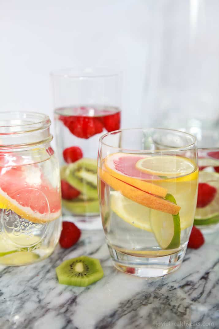 Three different kinds of fruit infused water in serving glasses.