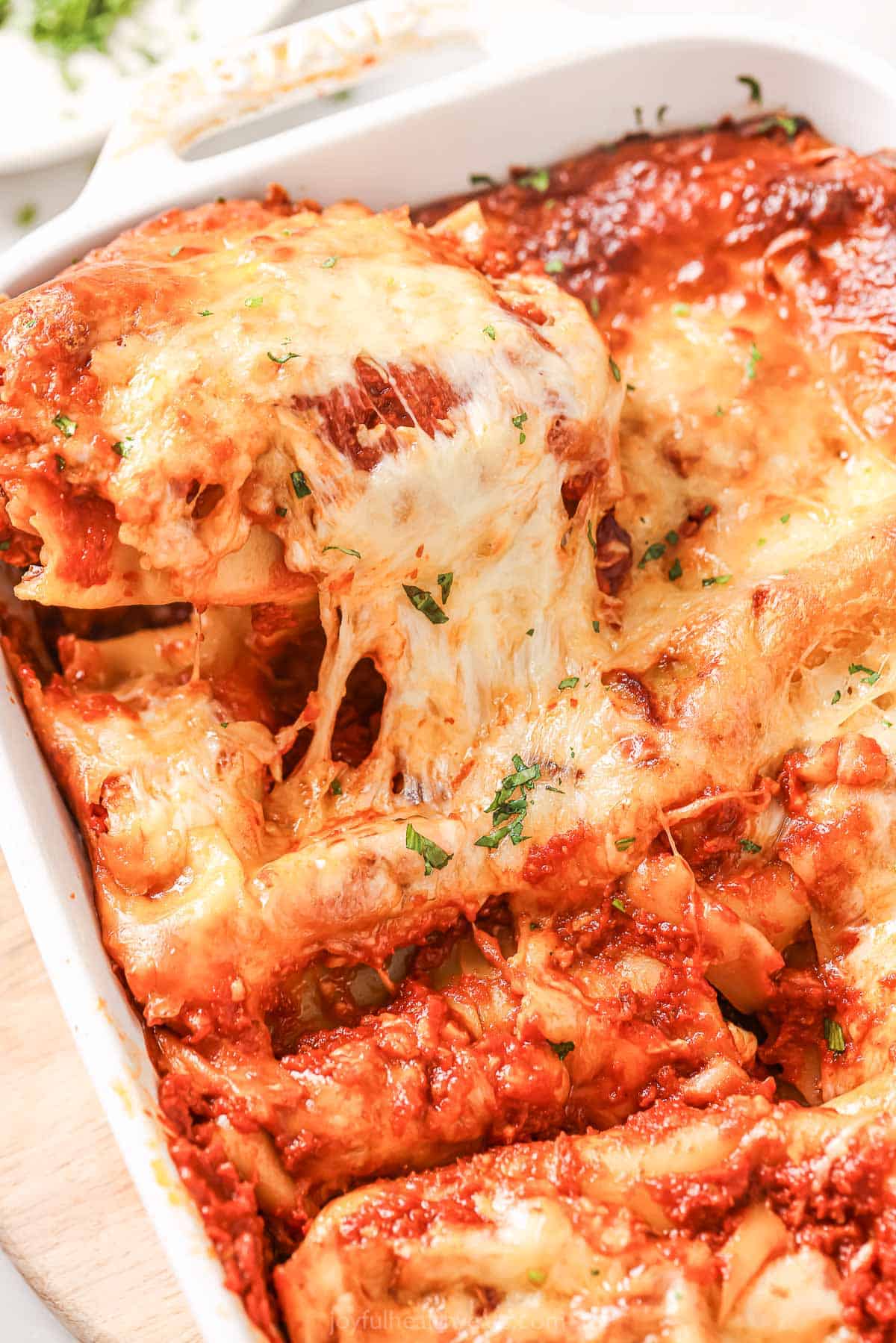 Close-up of the cheese-pull from these melty lasagna rolls with marinara sauce.